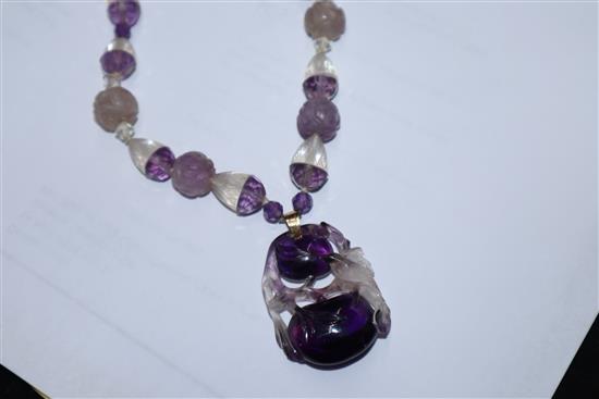 A Chinese amethyst and rock crystal pendant hung from a carved amethyst and rock crystal necklace, pendant 38mm.